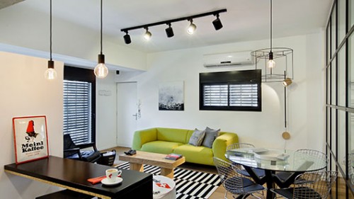 חלל האירוח כולל פינת אוכל וסלון המרוהטים בסגנון מודרני אקלקטי, המשלב רהיטי יוקרה עם פריטים מאיקאה. צילום: בועז לביא