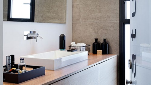 דלת מזכוכית חלבית מובילה אל חדר הרחצה מאפשרת מעבר אור יום מן החלון הנמצא בחדר אל שאר הבית. צילום: בועז לביא