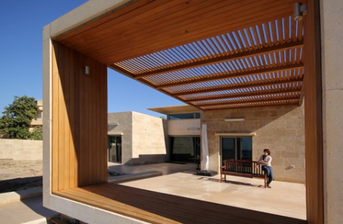 פתח רחב בחזית המרפסת של בית בשבי ציון ממסגר את הים הנשקף ממנו