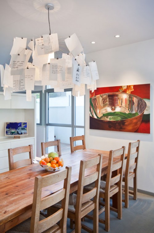 ציור שמן גדול של נעמי מנדל, ציור שמן קטן של אפרת גלנור וגוף תאורה איקוני של אינגו מאוואר שולבו במטבח. צילום: בועז לביא 