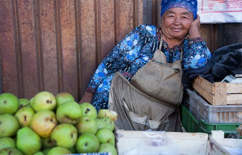 אוש, קירגיזסטאן. לאחר שקניתי תפוח מהדוכן שלה, שמחה הסוחרת להצטלם. צילום: עודד וגנשטיין
