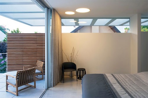 חדר השינה תופס את רוב שטחה של הקומה העליונה ונפתח אל מרפסת פרטית,הממוקמת מעל צמרות עצי הגינה | צילום: אורי אקרמן ומיקלה ברסטו