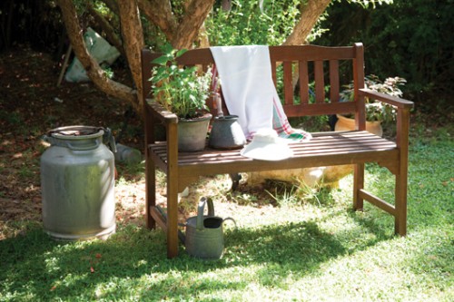 ספסל עץ וכלים ישנים המשמשים לשתילת צמחים