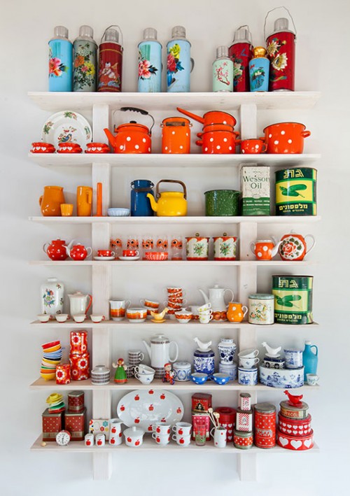 נקודת הצבע המרכזית במטבח הלבן נוצרה באמצעות שורת מדפים צרים המגיעים עד התקרה המטבח ומרכזים את אוסף כלי הווינטג' של בעלת הבית  | צילום: בועז לביא 
