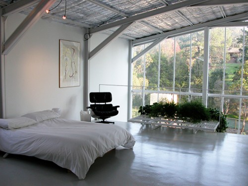חדר השינה מעוצב בסגנון מינימליסטי. הנוף המרהיב הוא השחקן המרכזי בחלל