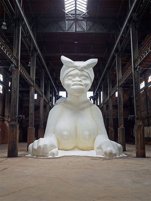 Kara Walker "A Subtlety, or the Marvelous Sugar Baby", סוכר, 2014.  הוצג במפעל הסוכר דומינו, ברוקלין, ניו יורק, בהזמנת Creative Time. באדיבות גלריה Sikkema Jenkins & Co. ניו יורק © 2014 Kara Walker       צילום: Jason Wyche