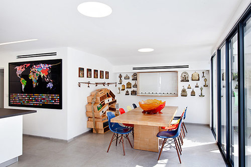 אזור פינת האוכל כולל כיסאות פלסטיק מקוריים של איימס, שידת מגירות בעיצוב קבוצת Droog Design וחנוכיות ברזל המזכירות את אוספי היודאיקה המוקדמים של בעל הבית | צילום: בועז לביא