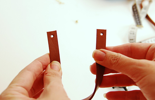 קחו את שארית החגורה (ללא האבזם), מדדו 20 ס"מ וגזרו. נקבו חור בשני קצוות הרצועה (השאירו חצי ס"מ שוליים) בצעו את השלבים 1-3 גם בחגורה השנייה | צילום: דליה באירמוב