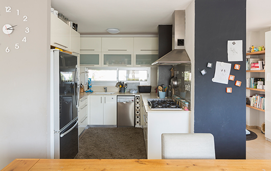 המטבח קטן אך פונקציונלי ומספיק לצורכי בני הבית. הפרט היחיד שהשתנה הוא לוח זכוכית מעל לכיריים | צילום: שי אפשטיין