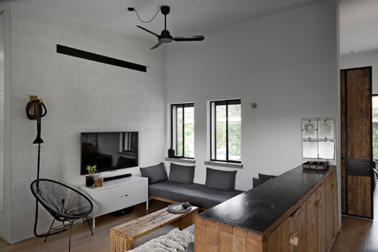 שידה שנוצרה מעץ מסיבי ממוחזר תוחמת את פינת המשפחה | צילום: קובי קלמנוביץ