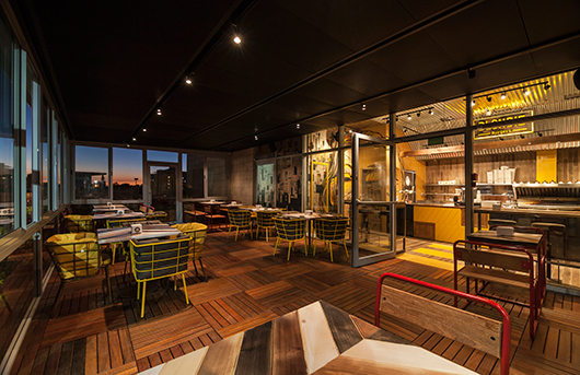 שביל צהוב מוביל מהמרפסת המקורה אל עמדת ההזמנות | צילום: ינאי דיטש