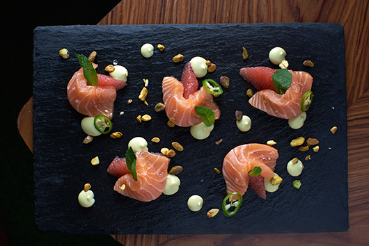 סשימי סלמון עם אשכולית אדומה, קרם ווסאבי ופיסטוקים | צילום: אנטולי מיכאלו