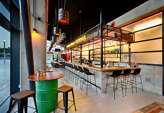 הבר ממוקם במרכז כמוקד התרחשות בחלל. אותיות ניאון מכריזות על הקונספט של המקום | צילום: ניצן הפנר