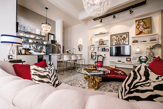 עומס עיצובי יוצר מראה בוהמייני. מבט כללי אל הסלון, המטבח ופינת העבודה | צילום: איתי סיקולסקי