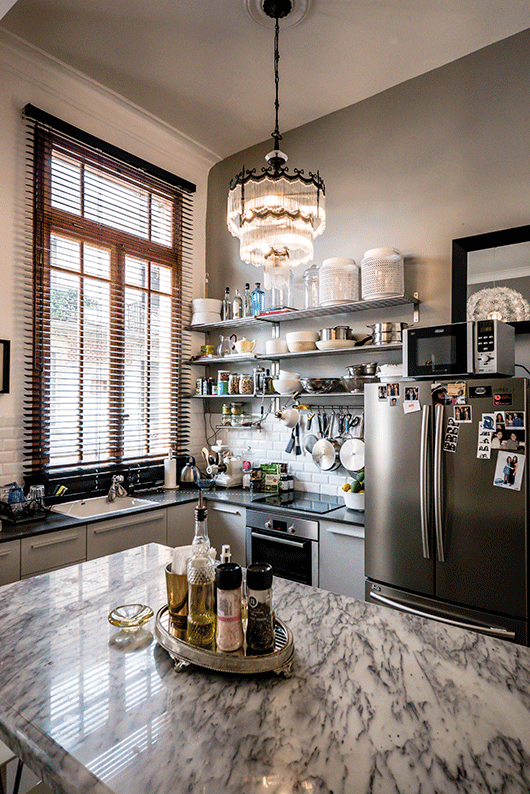 המטבח. נבחרה מנורה בסגנון אר־דקו שלא בהכרח אופייני למקום בישול | צילום: איתי סיקולסקי