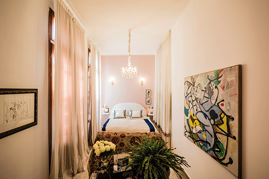 חדר השינה המרכזי הוא בעל אופי תיאטרלי. מימין: ציור של משה רוזנטליס | צילום: איתי סיקולסקי