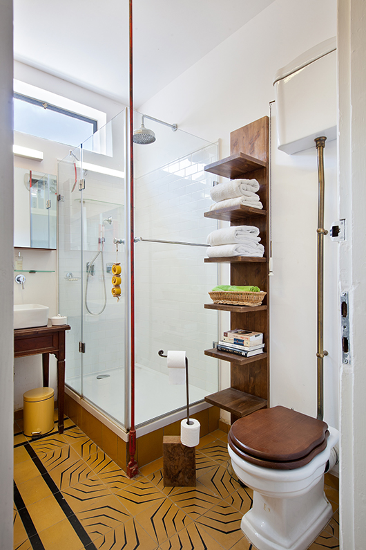 כבל פלדה מקורי נצבע באדום ומגדיר את שטח המקלחון, כאלמנט עיצובי שכאילו היה כאן מאז ומעולם. מתלה מגבות בצורת סולם מבליט אותו ומכניס רוח צעירה לעיצוב הווינטג'י | צילום: בועז לביא