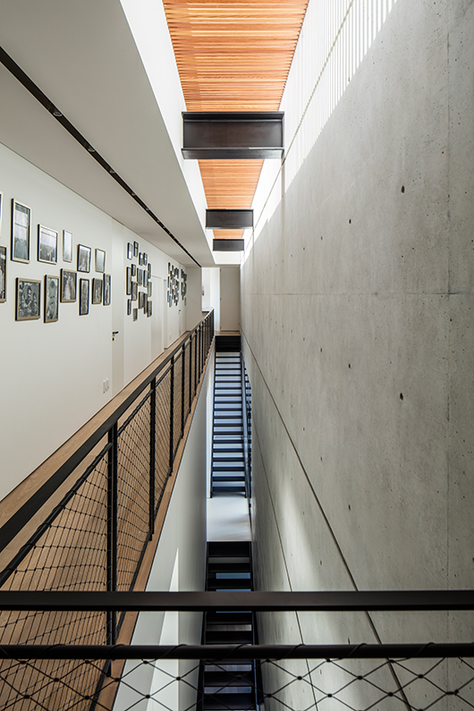 גרם מדרגות חותך את המבנה ומאפשר קו מבט עד למרתף | צילום: עמית גרון