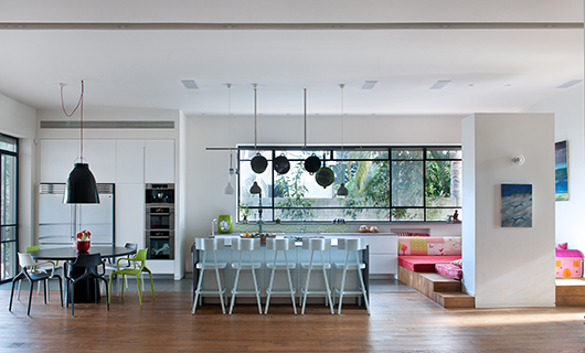 בבית במושב חרוצים&nbsp;תוכננה פינת ילדים מקסימה ומזמינה במיקום מפתיע: צמוד למטבח, על במת עץ שרופדה במזרונים ובכריות צבעוניות | צילום: עמית גושר