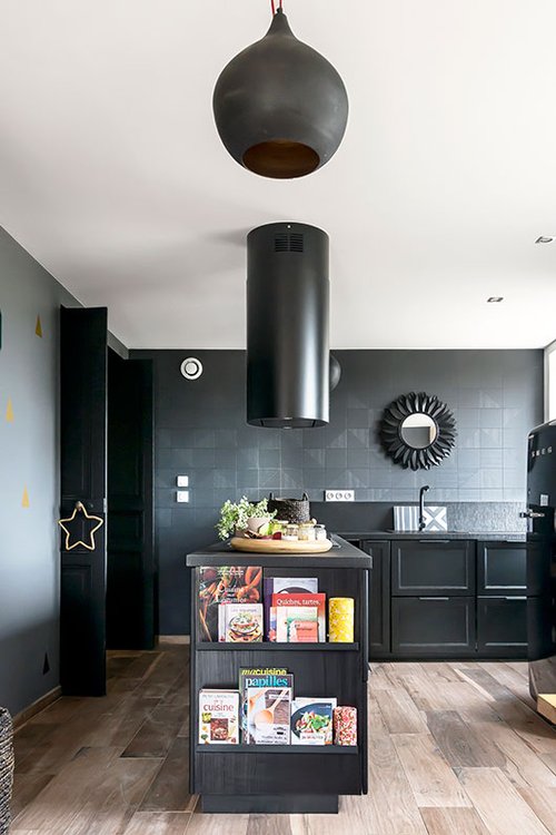 טפט דמוי אריחים ומשחק פיסולי בין גוף התאורה לקולט האדים יוצרים מראה דרמתי למטבח | צילום: Benoit Alazard 