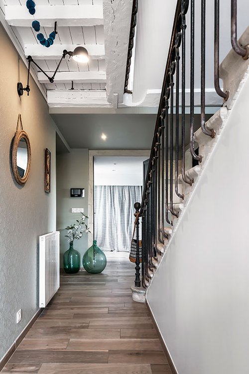 מדרגות אבן ומעקה בסגנון אר דקו מובילים אל הקומה העליונה שלה אופי בהיר וחמים | צילום: Benoit Alazard 