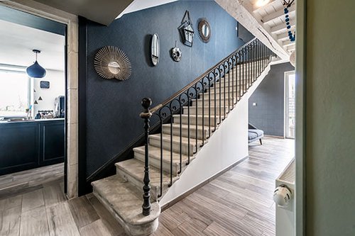 מראות במגוון צורות מוסיפות אור ועניין לקירות הכהים | צילום: Benoit Alazard 