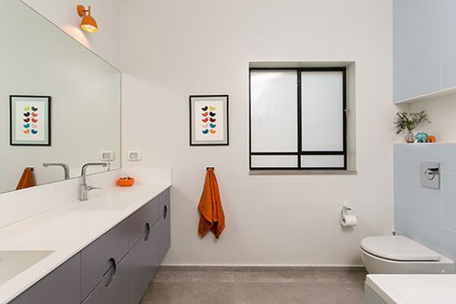 אביזרים בודדים בכתום מעניקים חמימות לחדר הרחצה של הבנות | צילום: שירן כרמל