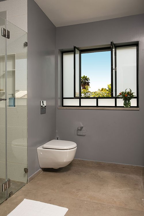 למעט האזורים הרטובים המחופים באריחי קרמיקה, כל קירות בחדרי הרחצה מטויחים וצבועים | צילום: שירן כרמל