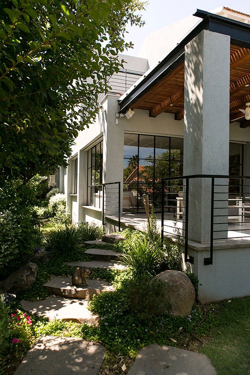 השטחים הציבוריים החיצוניים מרוצפים בבטון מוחלק ומדרכי בזלת אמורפיים מובילים מהחזית אל הגינה שמאחור | צילום: שירן כרמל