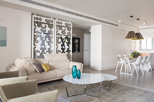  מבט למטבח: במקום הקיר שחצץ בין פינת האוכל לאזור הפרטי נבנה ארון לבן דו צדדי המייצר את ההפרדה הדרושה בין האזורים, חוסך מקום, ומוסיף שטחי אחסון הן בפינת האוכל והן במסדרון שמעברו השני | צילום: סיון אסקיו