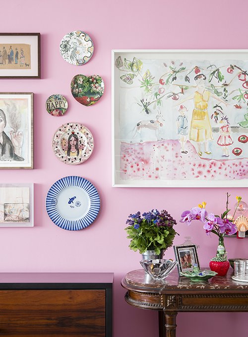 צבע הקיר מהווה רקע לשלל הפורטרטים התלויים עליו מאוסף בעלת הבית | צילום: Fran Parente