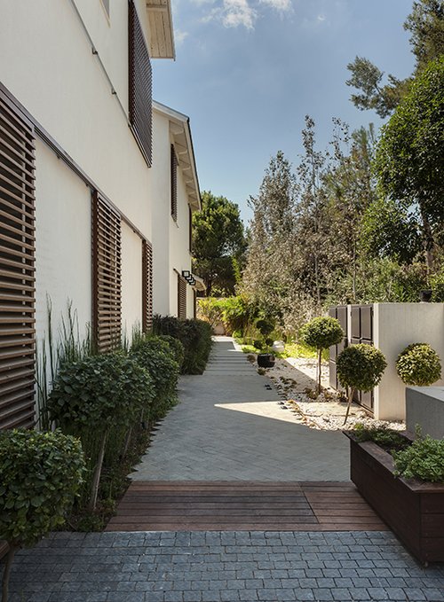 שילוב בין משטחי ריצוף בדגמים גרפיים שונים יוצרים משחק גרפי כבר בשביל הכניסה לבית | צילום: עודד סמדר