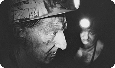 כורים עובדים על הברכיים בתוך מנהרה צרה, במקום שתעלת הקידוח נגמרת